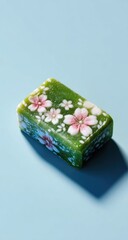 Green soap bar with painted pink cherry blossoms