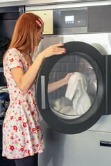 Woman using modern laundry machine for cleaning