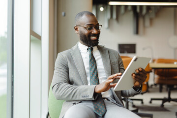 Confident businessman using tablet in modern office