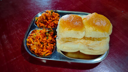 sev-tomato curry and pav ( bread ) in the plate in india.