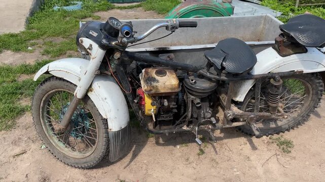 Vintage motorcycle with a sidecar on a dirt path, suitable for retro transport themes