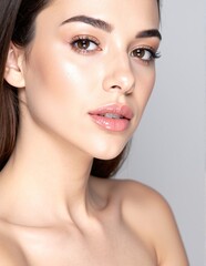 Obraz premium A woman with flowing, long brown hair styled elegantly, wearing vibrant pink lipstick that enhances her bright smile, exuding confidence and charm.