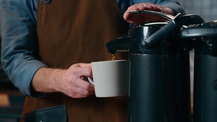Unrecognizable Caucasian man in apron waiter serving entrepreneur making coffee employee staff giving order client worker barista guy male pouring tasty drink into mug small business in cafeteria cafe
