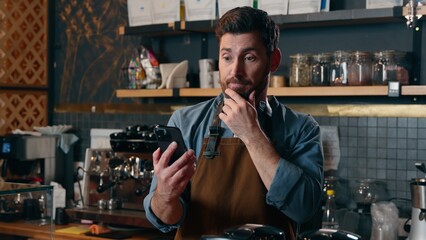 Confused Caucasian barista employee guy waiter owner worker male man using mobile phone upset manager owner entrepreneur demonstrating gadget green screen smartphone in cafeteria frustration tech app