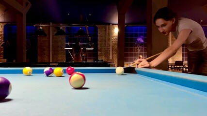 Brunette teenager girl holding arm on billiard table, playing snooker game or preparing aiming to shoot pool balls. sport game snooker billiards