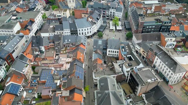 Aerial view of a bustling town square, contrasting terracotta rooftops with the muted tones of the buildings, Hasselt, Flanders, Belgium.