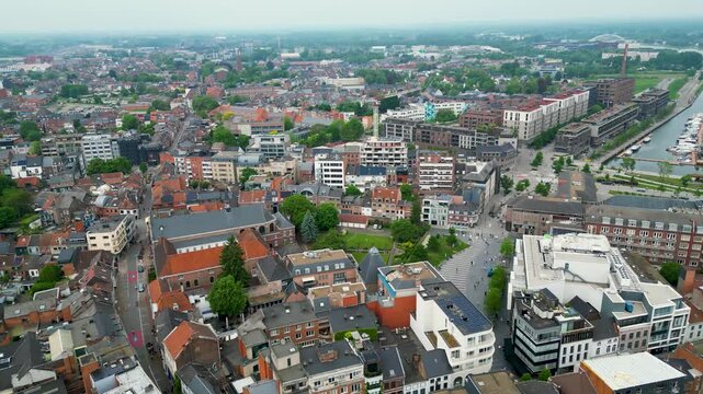 Aerial view of the cityscape with red rooftops contrasting against modern buildings and green spaces, creating a harmonious blend of old and new, Hasselt, Flanders, Belgium.