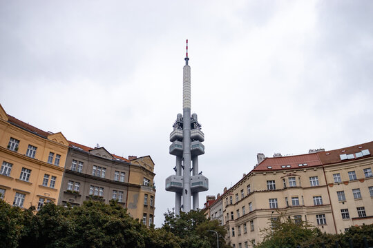 PRAGUE, CZECHIA - 2. October 2024: Žižkov Television Tower in between residential buildings of the city. Famous landmark with the babies sculptures (Miminka) by David Čern&yacute;.
