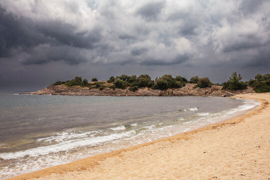 beautiful landscape with a beach at the sea and dramatic rain clouds