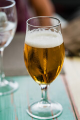 a glass of beer on a table with a blurred background