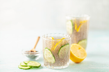 Chia seed water with lemon and cucumber slices in drinking gasses on wooden table. Drink for a healthy diet