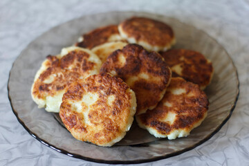 A plate of golden-brown curd cheesecakes stacked neatly