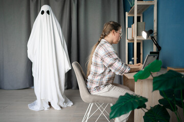 Concept of afterlife and memory for lost love. Sad depressed woman working at home while male ghost...