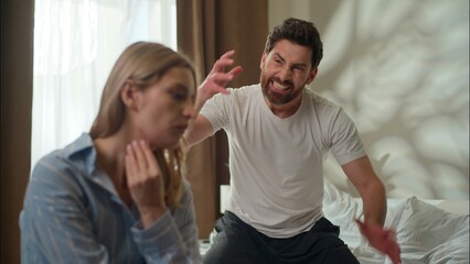Fototapeta premium Furious Caucasian guy shout arguing with anxious girlfriend in bedroom family fight relationship psychology conflict man girl divorce annoyed boyfriend speak frustrated woman headache stress quarrel