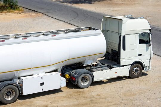 Trucks with triler tank of flammable liquid fuel wait at a storage facility waiting for dispatcher to send it on a trip
