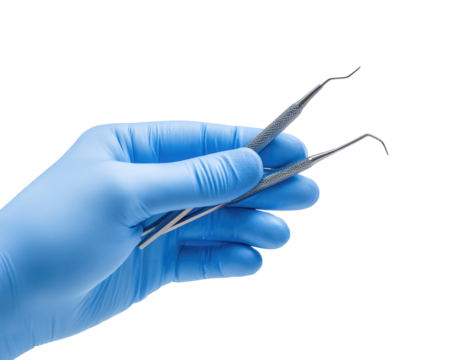 A gloved hand holds dental instruments
