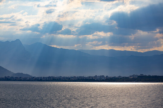 Mountains shrouded in mist and rays of sunlight breaking through the clouds