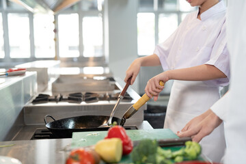 Group of young female chef wearing white apron during preparing food and learning cooking in kitchen