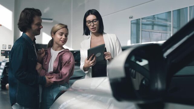 Car dealership scene featuring customers discussing vehicle options with a salesperson, showcasing a modern and inviting automotive environment