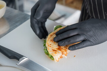 The chef prepares a flatbread with herbs. 