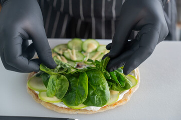 The chef prepares a flatbread with herbs. 