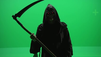 Cloaked Grim Reaper with Glowing Red Eyes Holding a Scythe Against a Vivid Green Screen Backdrop Creating A Spooky and Mysterious Shadowy Atmosphere