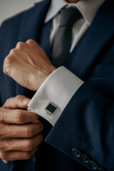 Business Man in Suite Fixing Cufflinks