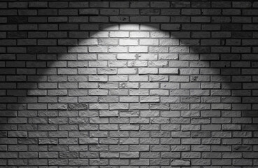 Brick wall illuminated by spotlight in black and white  
