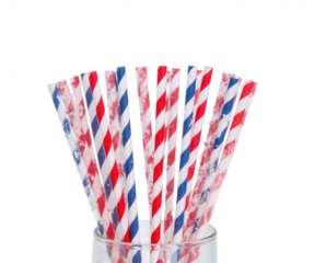 A vibrant display of red white and blue striped drinking straws arranged patriotically in a clear glass against darkness