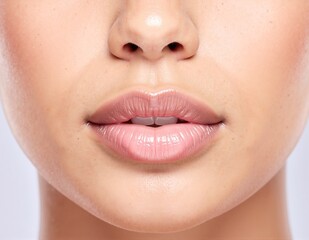 Fototapeta premium A close-up view of a pair of full, luscious lips, slightly parted to reveal a hint of teeth, showcasing a soft, natural pink hue and subtle gloss.