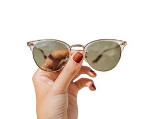 A fashionable pair of sunglasses, held delicately by a manicured hand
