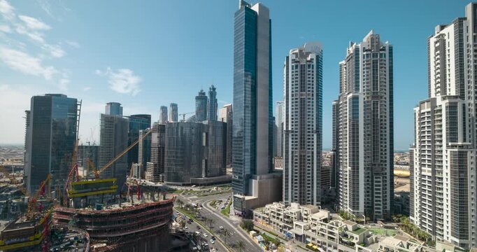 Dubai business district skyline timelapse video with ongoing construction and moving cranes