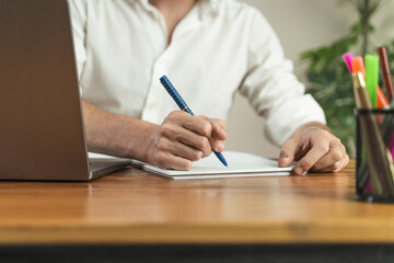 Close-up of a businessman's hands writing notes or signing a contract at his office desk. Concept of business agreement, education and professional work.