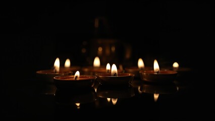 Candles Highlighted on a Shiny Surface Against Dark Backdrop