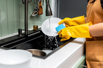 Close up woman hand washing plate. Female housekeeper cleaning some dish plate after dining. Housework Cleaning in the house