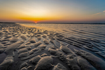 The sky turns a beautiful color during sunset on the deserted beach of Terschelling
