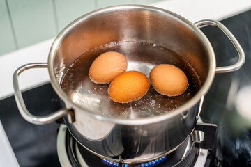 Boiled eggs in a pot. Chicken eggs boiling in saucepan on gas stove