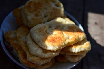 Traditional Bulgarian home made deep fried  patties  covered with sugar  оn rustic backgroud.Mekitsa or Mekica,  on wooden  rustic  background. Made of kneaded dough that is deep fried 