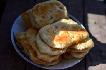 Traditional Bulgarian home made deep fried  patties  covered with sugar  оn rustic backgroud.Mekitsa or Mekica,  on wooden  rustic  background. Made of kneaded dough that is deep fried 