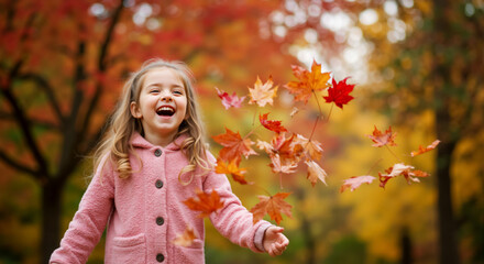 Laughing girl playing with falling autumn leaves. Happy child having fun in a park in fall.