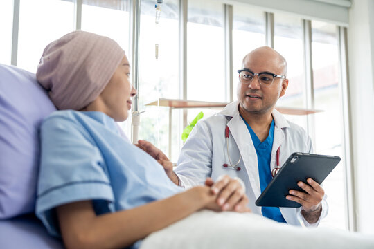 Male doctor visiting female cancer patient with care and compassion in hospital room. Oncology support medical consultation healthcare and hope. Doctor reporting medical test results to the patient