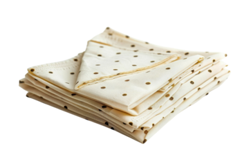 Elegant cream napkins with gold polka dots neatly stacked on a white surface in a bright setting