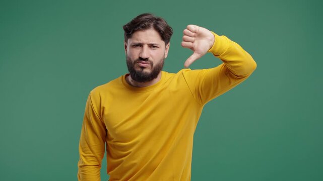 Mature bearded man expresses disapproval with thumbs down gesture - dislike