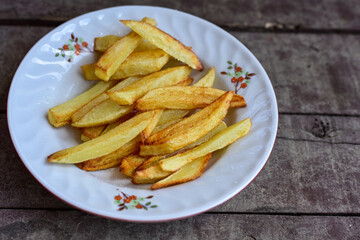   French fries on wooden background. Home made   organic    potatoes