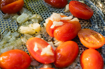 Close-up of fresh juicy cherry tomatoes, sliced in half, being prepared for cooking. Healthy eating and food background concept