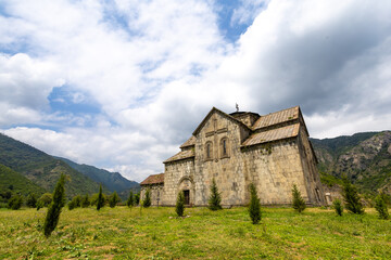 Armenia &ndash; The medieval Akhtala Monastery Fortress in Lori Province, surrounded by mountains and greenery under a partly cloudy sky.