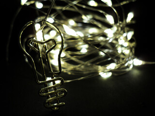 Close-up of a silver lightbulb bookmark on black with bokeh lights behind. Perfect for creativity, minimalist design, or seasonal inspiration projects.
