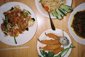 Delicious thai food dishes sitting on restaurant table, film photography