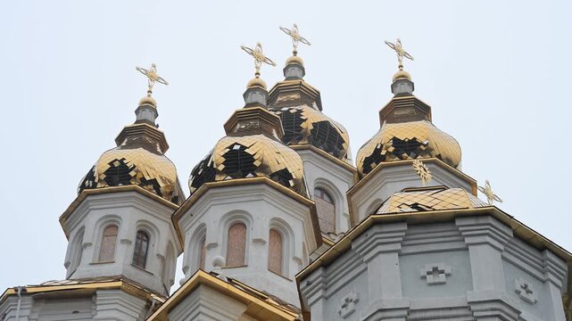 The golden domes of the Holy Myrrh-Bearing Women Church in Kharkiv show shrapnel damage, evidence of the shelling of Ukraine's cultural sites and civilian areas during the ongoing conflict.