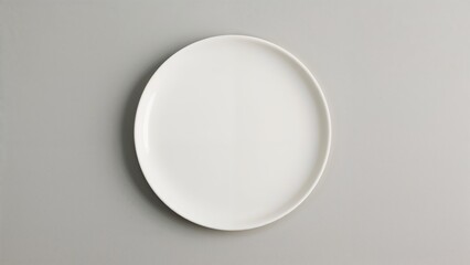 Bird's-eye shot of a sleek, low-rimmed round plate set on a muted gray background